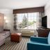 La Quinta Inn & Suites by Wyndham Bakersfield North guest room with sofa, armchair and large window