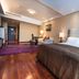 Hua Bin International Hotel Beijing guest room with king bed, desk, seating area and wood floors