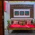 Kamar Kamar Boutique Hotel in Kuta: carved wooden daybed with red cushions and framed wall art