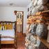 Hotel La Villa Serena Antigua room with rustic stone wall, carved bed and TV