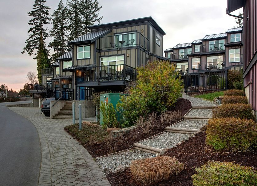 Sooke Harbour Resort & Marina in Sooke, exterior of modern guest suites with balconies and landscaped path
