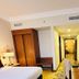 City Seasons Al Hamra Hotel in Abu Dhabi guest room with twin beds, hallway, desk and wardrobe