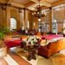 Grande Hotel e Termas de Araxá lobby with chandeliers, red carpet, leather seating and tall arched windows in Araxá