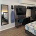 Studio 6 Vicksburg, MS room with bed, desk, wall-mounted TV and mirror