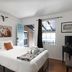 Trail Rider's Inn in Tombstone bedroom with queen bed, open door, window, and rustic decor