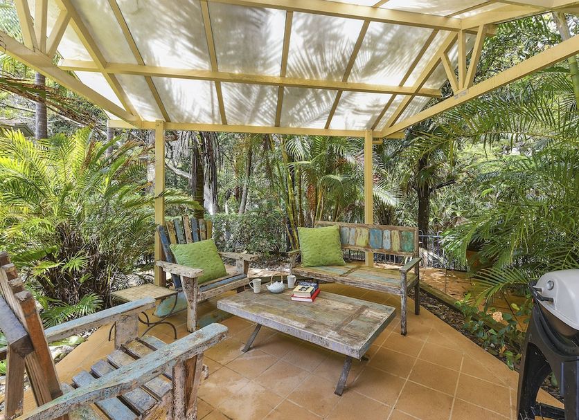 Azura Beach House B&B in Port Macquarie features a covered tropical patio with seating and lush greenery