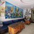 Funny Guesthouse Ho Chi Minh City lobby with blue sofa, wooden tables, and colorful mural wall