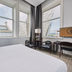 Titanic Hotel Belfast guest room with large windows, city views, and a sitting area in Belfast.