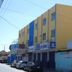 Hotel Nacional Montes Claros exterior on a street in Montes Claros with yellow facade and parked cars