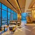Hilton Garden Inn Bangkok Riverside lobby lounge with floor-to-ceiling windows and city skyline views