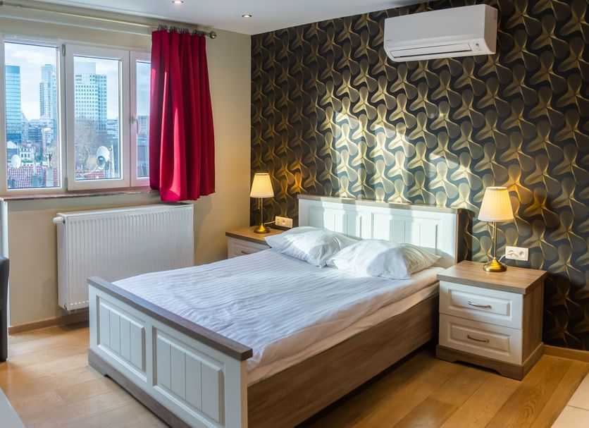 Wellness Apart Hotel Brussels guest room with double bed, city view window, and armchair