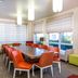 Hilton Garden Inn Orange Beach Beachfront meeting room with long table, colorful chairs, and large windows
