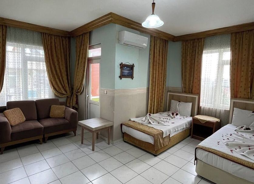 Best Life Apart Hotel Alanya room with two single beds, sofa, windows, and tiled floor
