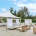 Una Hotels Forte Dei Marmi outdoor lounge with daybeds, wooden chairs and poolside seating
