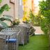 Arabella Residence in Cairo, outdoor seating area with wicker chairs, potted palms, and artificial grass