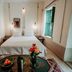 Riad Dar Ayur in Marrakech guest room with a double bed, bedside lamps, and green-shuttered window
