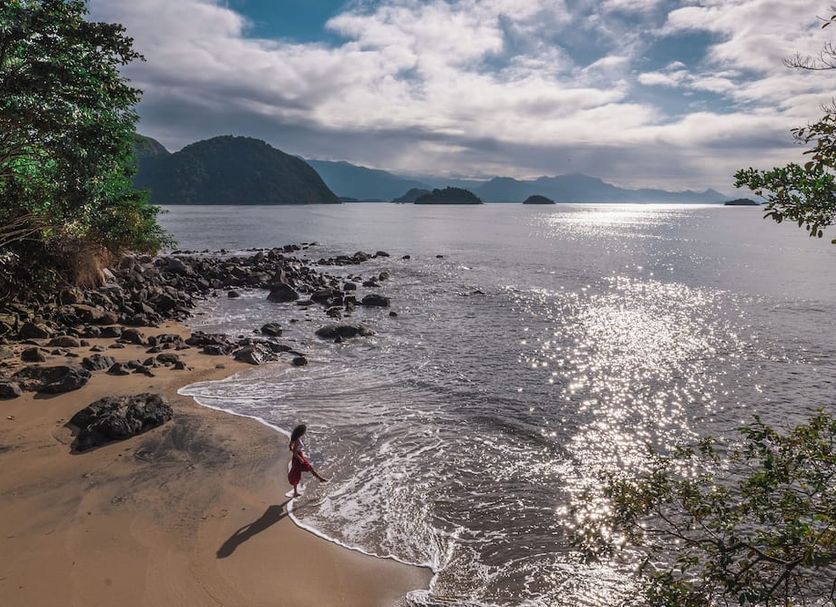 Casa Luz Paraty beach with shoreline, calm sea, and distant green islands