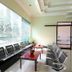 Waiting area at RedDoorz @ Seturan Raya 2 in Depok with rows of black chairs and coffee tables by a large window