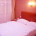 Binhai Mingzhu Hotel Beijing guest room with double bed, bedside lamp and window curtains