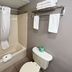 Studio 6 Suites Elkhart, IN bathroom with tub-shower combo, towels, and wall shelf