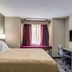 Quality Inn & Suites Grove City-Outlet Mall guest room with king bed, desk, chair and wall-mounted TV