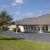 Lakewood Inn & Suites in Dowagiac exterior with gray roof, paved drive, and manicured lawn