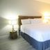 Doolan's Shore Club in Spring Lake Heights guest room with a neatly made bed, bedside lamps, and coastal wall art.