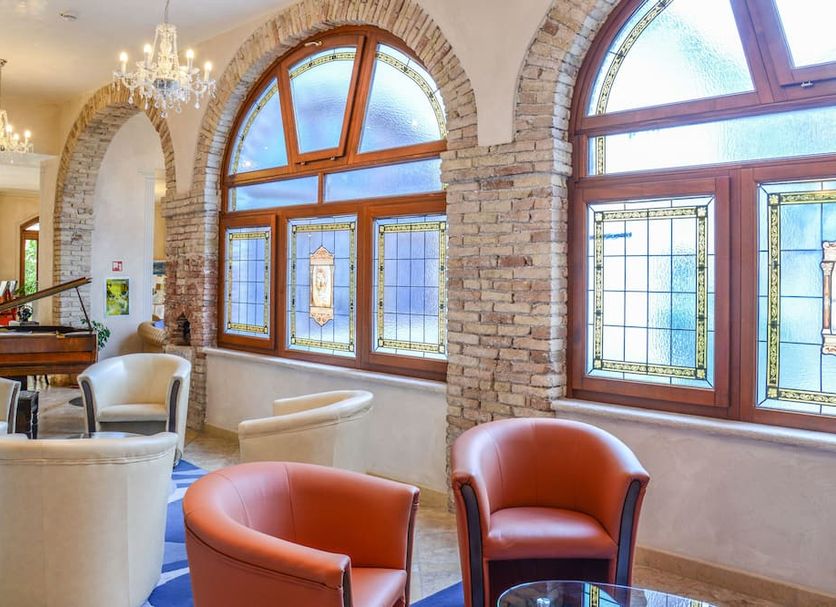 Hotel Antico Monastero lounge with arched windows and white armchairs in Toscolano Maderno