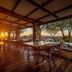 Gondwana Etosha Safari Lodge in Okaukuejo: sunset view from open-air deck with tables and chairs