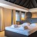 Parkhotel Horst guest room with double bed, skylit ceiling, and modern wall lighting in Horst