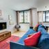 Lsa Liberdade by Numa in Lisbon living room with blue sofa, TV, dining table and large windows
