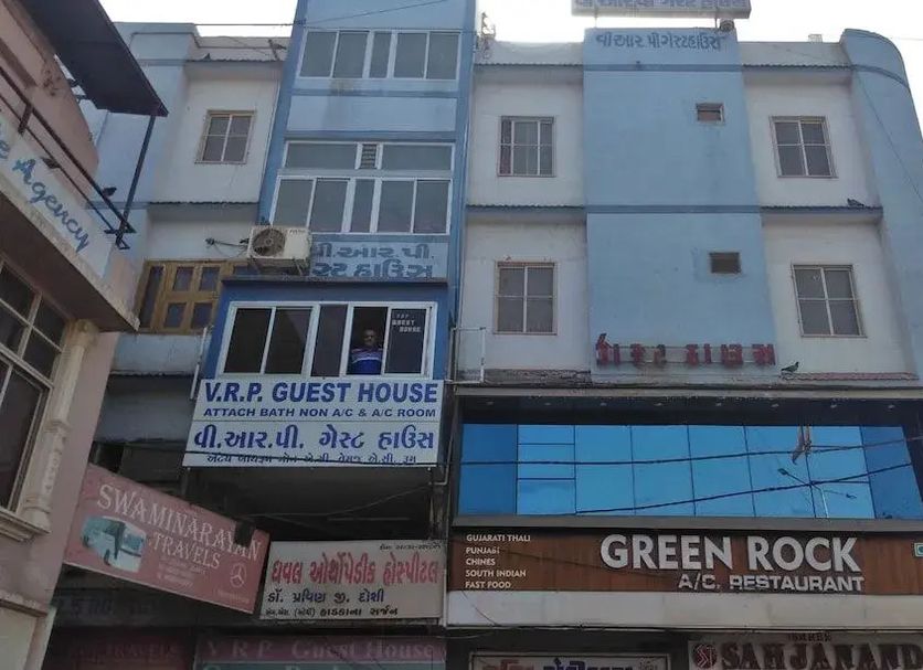 Vrp Guest House in Bhuj exterior with blue facade and Green Rock A/C Restaurant sign