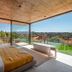 Herdade da Malhadinha Nova bedroom with floor-to-ceiling windows, countryside view, and freestanding tub in Beja