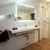 Hotel Garni Jägerhof in Sigmaringen bathroom with double sink, glass shower and wood-look floor