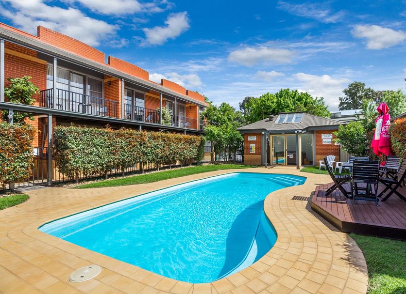 National Hotel Complex Bendigo pool courtyard with outdoor seating and two-story building in Bendigo