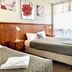 Central Motel Mildura in Mildura: guest room with two beds, wood paneling and large window