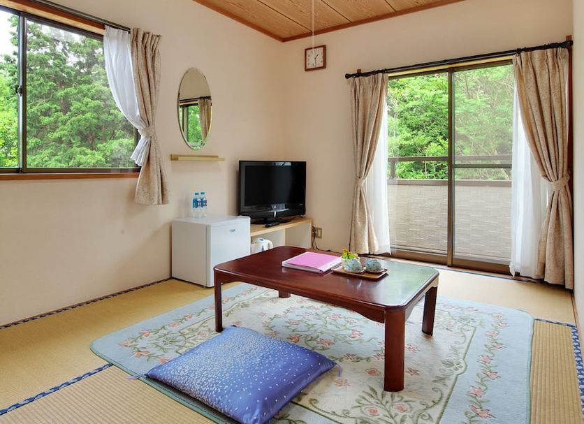 Resort Hotel Chateau Le Fleur in Itō guest room with tatami floor, low table, floor cushions, and balcony view