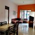 Patria Garden Hotel Blitar room with dining table, seating area, orange accent wall and city view