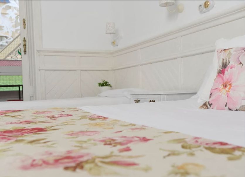 La Martina Hostal in Barcelona guest room with floral bedding and white paneled walls