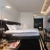 NYX Tel Aviv hotel room with bed, desk, wall-mounted TV, and patterned wallpaper in Tel Aviv