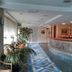 Hotel Art Sarajevo lobby with marble reception desk, blue patterned runner, and indoor plants