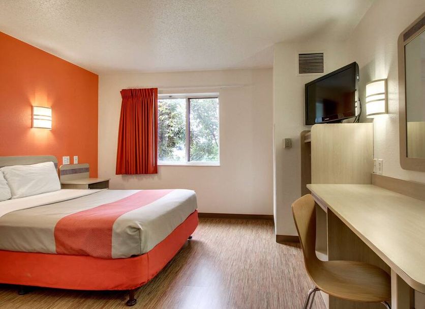 Motel 6 Springfield IL room with bed, desk, TV, window and orange accent wall
