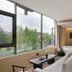 Terra Art Sky Garden Boutique Hotel Chengdu room with floor-to-ceiling windows and city greenery view