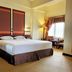 Hotel Sibayak International room in Berastagi with king bed, tall windows and seating area