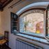Villa Di Sotto, Castelnuovo Berardenga room with bed and open window to stone courtyard