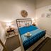 Waterside Inn Vieques guest room with twin bed, bedside lamps, wall art, air conditioner and mirror