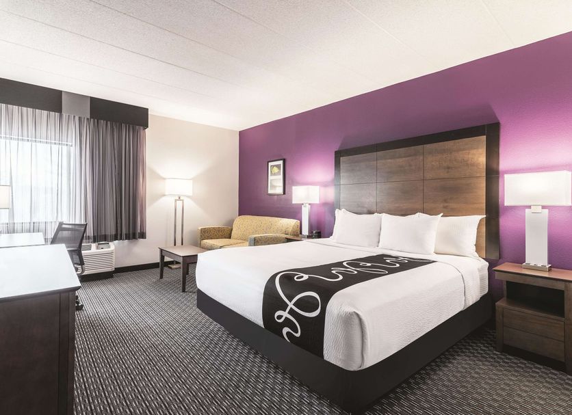 La Quinta Inn & Suites by Wyndham Salem NH guest room with king bed and purple accent wall