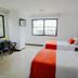 Hotel Pinares Plaza in Pereira guest room with two beds, desk, and large windows with water view