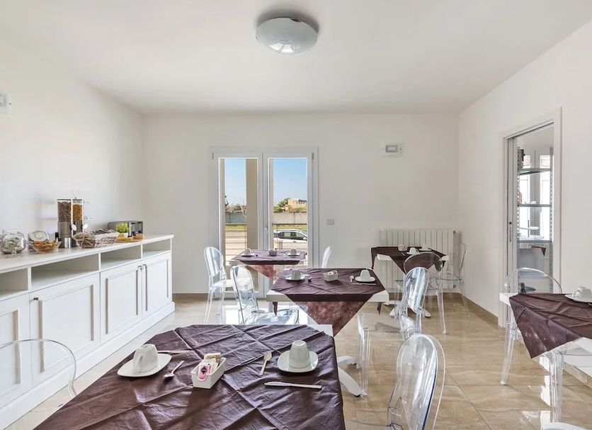 Breakfast room at Imperial Exclusive Rooms And Breakfast in Porto Cesareo with set tables and white cabinets