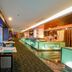 Swiss-Belhotel Mangga Besar in Jakarta dining area with large windows and a long illuminated bar